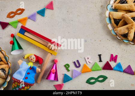 Vacanza ebraica Purim sfondo con amantaschen o hamans orecchie biscotti, maschera di carnevale e noisemaker Foto Stock