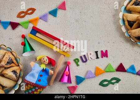 Vacanza ebraica Purim sfondo con amantaschen o hamans orecchie biscotti, maschera di carnevale e noisemaker Foto Stock