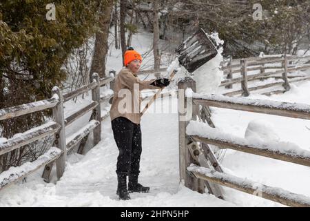 Paradise, Michigan - un lavoratore del Michigan Department of Natural Resources libera la neve lontano dalla piattaforma di osservazione a Tahquamenon Falls. Il fr Foto Stock