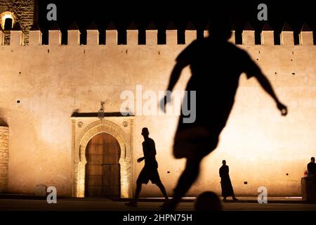 I giovani giocano a calcio di notte fuori dalla Kasbah degli Udayas a Rabat, Marocco, Nord Africa. Foto Stock