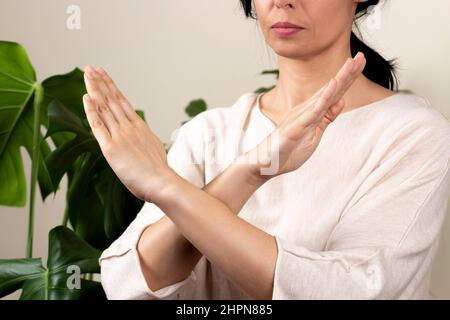 Mani incrociate. Rompere il simbolo di bias della giornata internazionale della donna. Le armi delle donne si incrociavano per mostrare solidarietà, impegno a richiamare pregiudizi, rottura Foto Stock