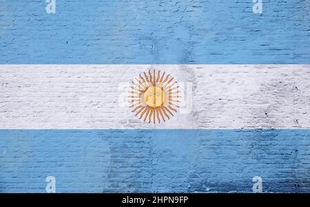 Foto full frame di una bandiera argentina intemperie dipinta su una parete di mattoni intonacati. Foto Stock