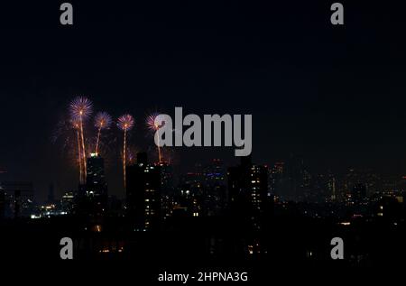 I fuochi d'artificio sull'East River di New York City esplodono il 4th luglio 2021, con i lucernari di Manhattan e Brooklyn visibili Foto Stock