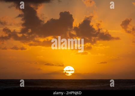 Sole sul Mare di Tasman, Spiaggia di Ohawe, South Taranaki, Isola del Nord, Nuova Zelanda Foto Stock