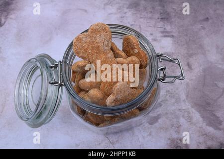 Dolci fatti in casa per cani "a forma di osso" in contenitore di vetro. Foto Stock