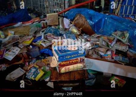 Dhaka, Bangladesh. 22nd Feb 2022. I libri bruciati e sporchi sono lasciati sulla strada.Un fuoco ha scoppiato al mercato del libro di Nilkhet, il più grande mercato del libro. Il fuoco è scoppiato intorno a 25 librerie che hanno provocato migliaia di libri bruciati. I vigili del fuoco hanno fatto scoppiare il fuoco dopo circa un'ora. (Foto di Rizwan Hasan/Pacific Press) Credit: Pacific Press Media Production Corp./Alamy Live News Foto Stock