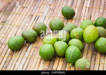 Mazzo fresco di avocado verde su sfondo di rete di legno Foto Stock