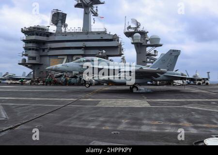 MAR DELLE FILIPPINE (Feb 21, 2022) un EA-18G Growler, assegnato ai 'Wizards' di Electronic Attack Squadron (VAQ) 133, fa un atterraggio arrestato sul ponte di volo della portaerei di classe Nimitz USS Abraham Lincoln (CVN 72). Abraham Lincoln Strike Group è in fase di implementazione pianificata nell'area delle operazioni della flotta USA 7th per migliorare l'interoperabilità attraverso alleanze e partnership, fungendo da forza di risposta pronta a supportare una regione indopacifica libera e aperta. (STATI UNITI Foto Navy di Mass Communication Specialist 3rd Classe Javier Reyes) Foto Stock