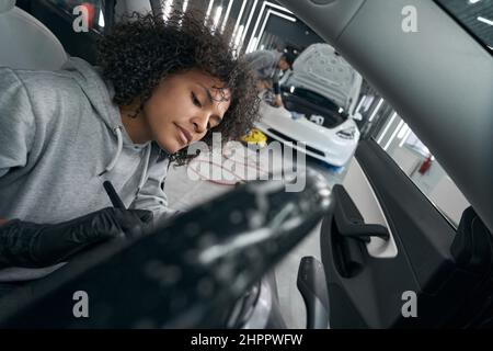 Detailer concentrato che rimuove lo sporco dalle superfici interne del veicolo Foto Stock