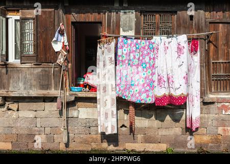 Lavanderia appesa ad asciugare nel cortile delle abitazioni sul canalside nel villaggio d'acqua di Wenzhou, Cina Foto Stock