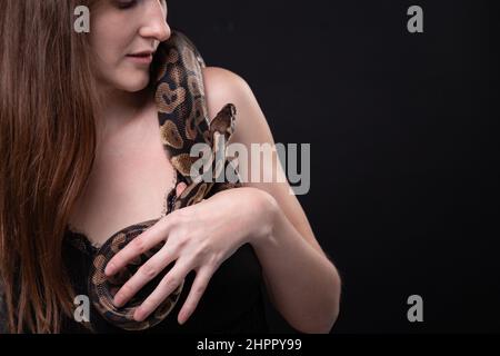 Foto di donna tenera con serpente sulla spalla Foto Stock