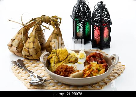 Ketupat Lebaran. Piatto tradizionale celebrativo di torta di riso con diversi contorni, popolare servito durante le celebrazioni di Eid al Fitr. Servito con Samba Foto Stock