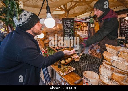 Cliente, fette di pane al ristorante del mercatino di Natale, Piazza del mercato principale, Kraków, Polonia Foto Stock