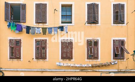 Pittoresca casa residenziale tipica italiana con vestiti appesi sulla linea di lavanderia Foto Stock