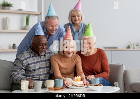 Gruppo multietnico di anziani che hanno festa di compleanno a casa Foto Stock