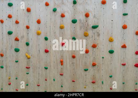 l'arrampicata colorata si tiene su un muro di legno Foto Stock