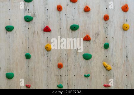 l'arrampicata colorata si tiene su un muro di legno Foto Stock