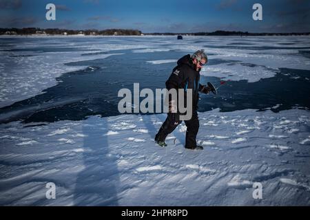 White Bear Lake, Stati Uniti. 27th Dic 2021. Scott Chamberlain, cammina attraverso una sezione di White Bear Lake, dove un fresco rivestimento di neve soffia attraverso il lago in White Bear Lake, Minnesota, il lunedì 27 dicembre 2021. Chamberlain ha pescato per il nord luccio Lunedi pomeriggio, dove c'era circa 7 pollici di ghiaccio sul lago. (Foto di Jerry Holt/Minneapolis Star Tribune/TNS/Sipa USA) Credit: Sipa USA/Alamy Live News Foto Stock