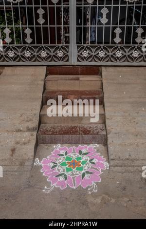 Rangoli è un'arte originaria del subcontinente indiano, in cui si creano motivi sul pavimento o su un tavolo utilizzando materiali come il calcare Foto Stock