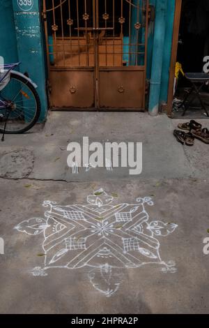 Rangoli è un'arte originaria del subcontinente indiano, in cui si creano motivi sul pavimento o su un tavolo utilizzando materiali come il calcare Foto Stock