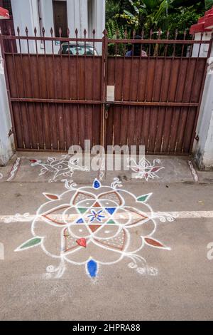 Rangoli è un'arte originaria del subcontinente indiano, in cui si creano motivi sul pavimento o su un tavolo utilizzando materiali come il calcare Foto Stock