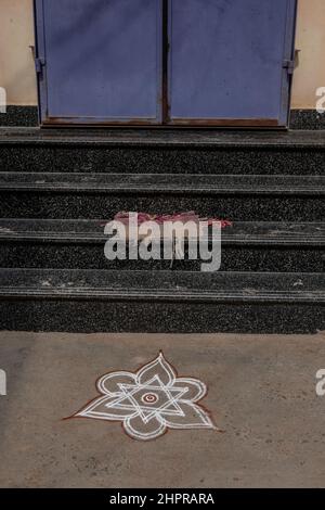 Rangoli è un'arte originaria del subcontinente indiano, in cui si creano motivi sul pavimento o su un tavolo utilizzando materiali come il calcare Foto Stock