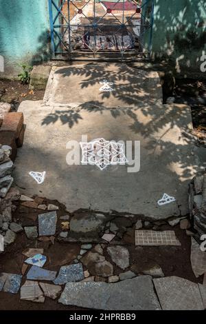 Rangoli è un'arte originaria del subcontinente indiano, in cui si creano motivi sul pavimento o su un tavolo utilizzando materiali come il calcare Foto Stock