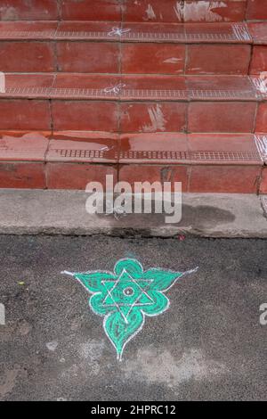 Rangoli è un'arte originaria del subcontinente indiano, in cui si creano motivi sul pavimento o su un tavolo utilizzando materiali come il calcare Foto Stock