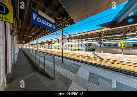 Fossano, Italia - 22 febbraio 2022: Stazione ferroviaria di Fossano con treni alla piattaforma, vista ad ampio angolo, trasporto ferroviario regionale in Piemonte Foto Stock