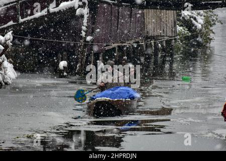 Un uomo allala la sua barca negli interni del lago dal durante le pesanti nevicate di Srinagar.la maggior parte delle zone della valle del Kashmir il mercoledì ha ricevuto nevicate – la prima pesante caduta della stagione nelle pianure – interrompendo le operazioni ferroviarie e di volo e portando alla chiusura del vitale nazionale Srinagar-Jammu autostrada, i funzionari qui hanno detto. (Foto di Saqib Majeed / SOPA Images/Sipa USA) Foto Stock