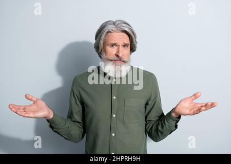 Ritratto di attraente puzzled uomo grigio-capelli shrugging spalle nessuna risposta isolato su sfondo grigio color pastello Foto Stock