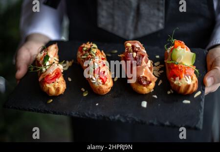 Eclairs con salmone, verdure fresche ed erbe aromatiche, spuntini gourmet. Foto Stock