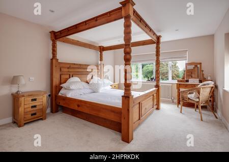 Swavesey, Cambridgeshire - Agosto 22 2018: Splendida camera da letto moderna arredata in uno stile tradizionale dominata da un grande letto a baldacchino in pino Foto Stock