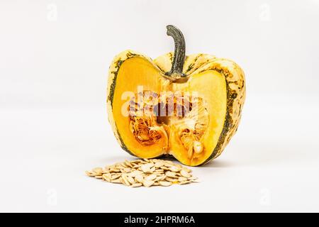 Zucca verde matura e semi isolati su sfondo bianco. Metà squash, elemento decorativo tradizionale festivo per Halloween o Thanksgiving Foto Stock