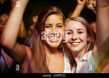 Avere il tempo della loro vita. Le giovani ragazze di un pubblico che si divertono con le loro band preferite. Foto Stock