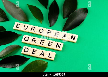 Frase "European Green Deal" composta da lettere poste su sfondo verde con laves verdi. Foto scattata sotto luce artificiale e soffusa Foto Stock