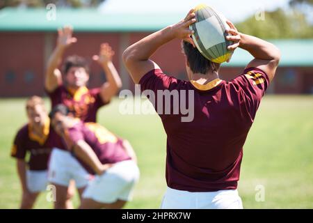 Passare la palla. Tiro retroguidato di un giovane giocatore di rugby che si è tirato fuori. Foto Stock