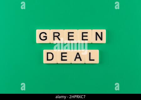 Frase "Green Deal" composta da lettere poste su sfondo verde. Foto scattata sotto luce artificiale e soffusa Foto Stock