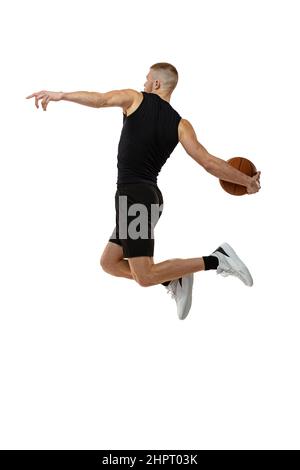 Streetball. Ritratto dinamico del giocatore di basket che salta con la palla isolato su sfondo bianco studio. Sport, movimento, concetti di attività. Dunk, inceppamento Foto Stock