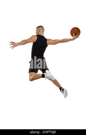 Ritratto dinamico del giocatore di basket che salta con la palla isolato su sfondo bianco studio. Sport, movimento, concetti di attività. Dunk, marmellata, roba Foto Stock