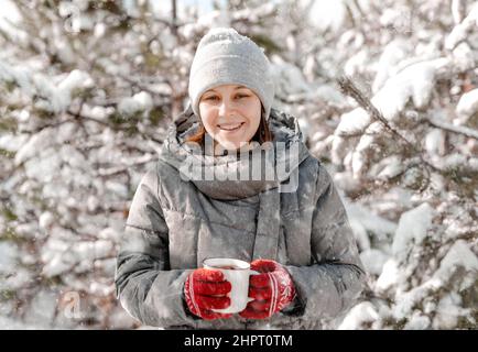 Ragazza in guanti di tenuta tazza Foto Stock