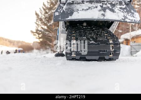 La parte posteriore della motoslitta in inverno. Cavalcare nella neve su una motoslitta. Sospensione posteriore di una motoslitta.motoslitta in condizioni invernali. Pelle estrema Foto Stock