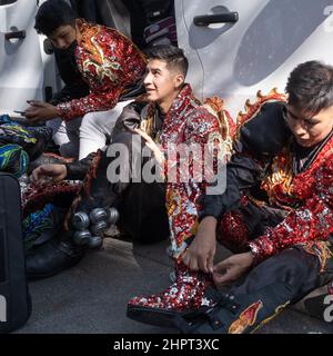 Giovani boliviani in abiti colorati e scarpe glittery pronti per esibirsi durante dia de la Hispanidad (giorno ispanico) a Gracia Avenue a Barcellona. Foto Stock