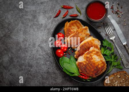Bistecche di maiale alla griglia in una padella con spezie con spazio copia Foto Stock