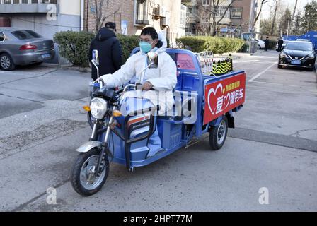 Pechino, Cina. 23rd Feb 2022. Un membro del personale consegna le necessità quotidiane per i residenti di un composto residenziale nel distretto di Fengtai di Pechino, capitale della Cina, 23 febbraio 2022. Pechino ha segnalato otto casi confermati COVID-19 trasmessi localmente dalle ore 11 di martedì alle ore 11 di mercoledì, le autorità locali ha detto Mercoledì. I casi provengono dall'Area di sviluppo economico-tecnologico di Pechino, dal Distretto di Chaoyang, dal Distretto di Tongzhou, dal Distretto di Shunyi e dal Distretto di Xicheng, secondo un comunicato stampa tenuto dal Governo comunale. Credit: Li Xin/Xinhua/Alamy Live News Foto Stock