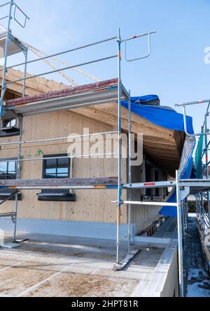 PRODUZIONE - 08 Febbraio 2022, Baden-Wuerttemberg, Schömberg: Un ponteggio è attaccato ad un nuovo edificio. Foto: Silas Stein/dpa Foto Stock