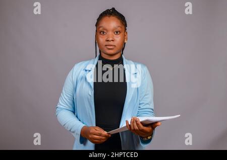 Bella donna d'affari africana che tiene le lime su uno sfondo bianco Foto Stock