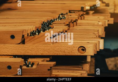 Vista delle gambe di legno ai cavalletti che si trovano in fila. Produzione di cavalletti. Officina di lavorazione del legno. Foto Stock