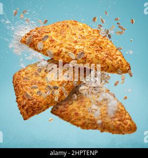 Triangoli appena sfornati con formaggio volano nell'aria. Cucina creativa per la colazione. Foto Stock
