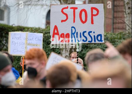 Amburgo, Germania. 23rd Feb 2022. I dimostranti mostrano, tra gli altri, le etichette con l'iscrizione "Stop AggRussia". Secondo la polizia, mercoledì ad Amburgo circa 200 persone si sono riunite di fronte al Consolato Generale russo per un raduno di solidarietà con l'Ucraina. Le organizzazioni giovanili di Amburgo del DOCUP, dei Verdi, della CDU e del FDP avevano chiesto il rally. Credit: Jonas Walzberg/dpa/Alamy Live News Foto Stock